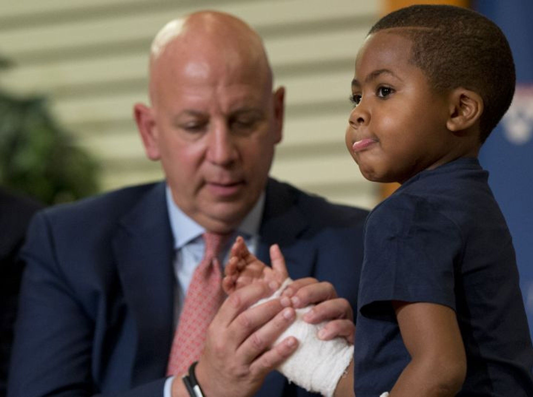 Dr. L. Scott Levin holds Zion Harvey's hands as he moves his fingers (Image: AP)