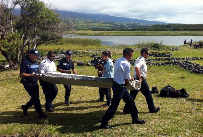 Police carry the debris from the unidentified aircraft from the area where it was discovered