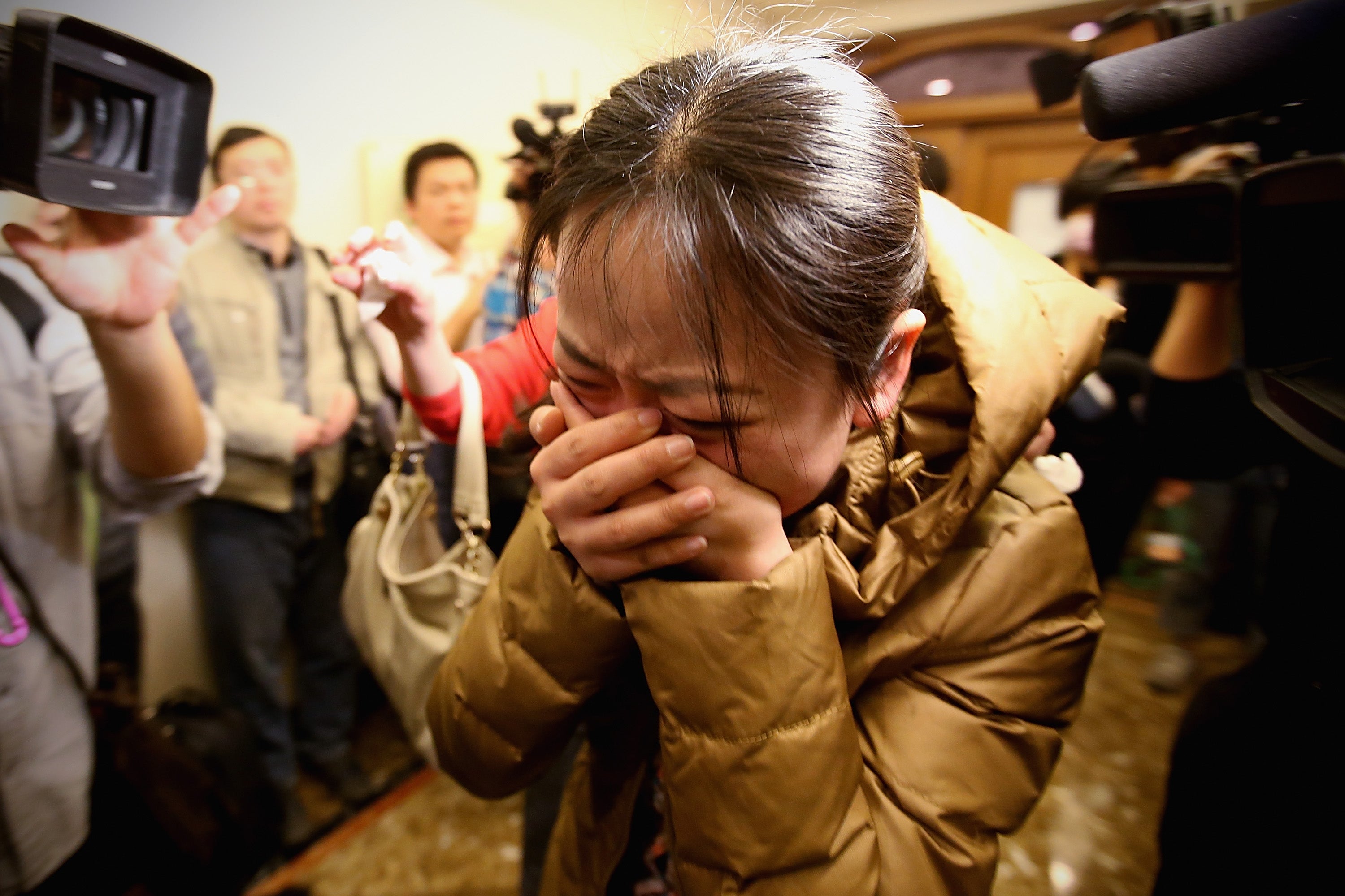 A relative of an MH370 passenger cries shortly after the plane's disappearance