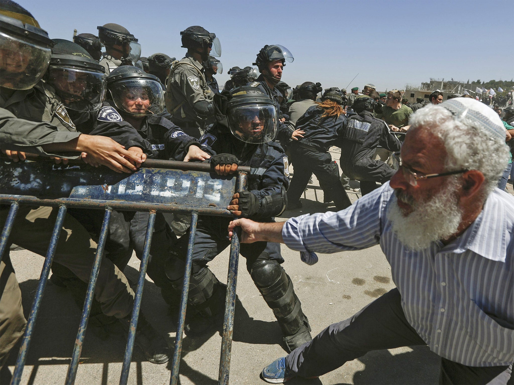 Israeli security forces scuffle with Israeli settlers in Beit El on the West Bank as 24 homes are demolished