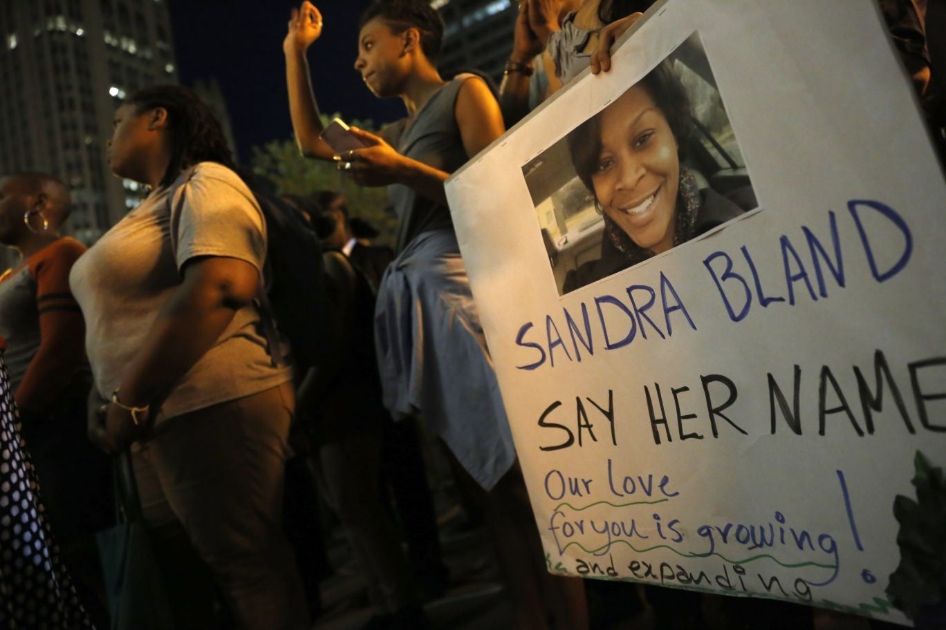 Demonstrators hold signs during a vigil for Sandra Bland, who died in police custody after apparently committing suicide.