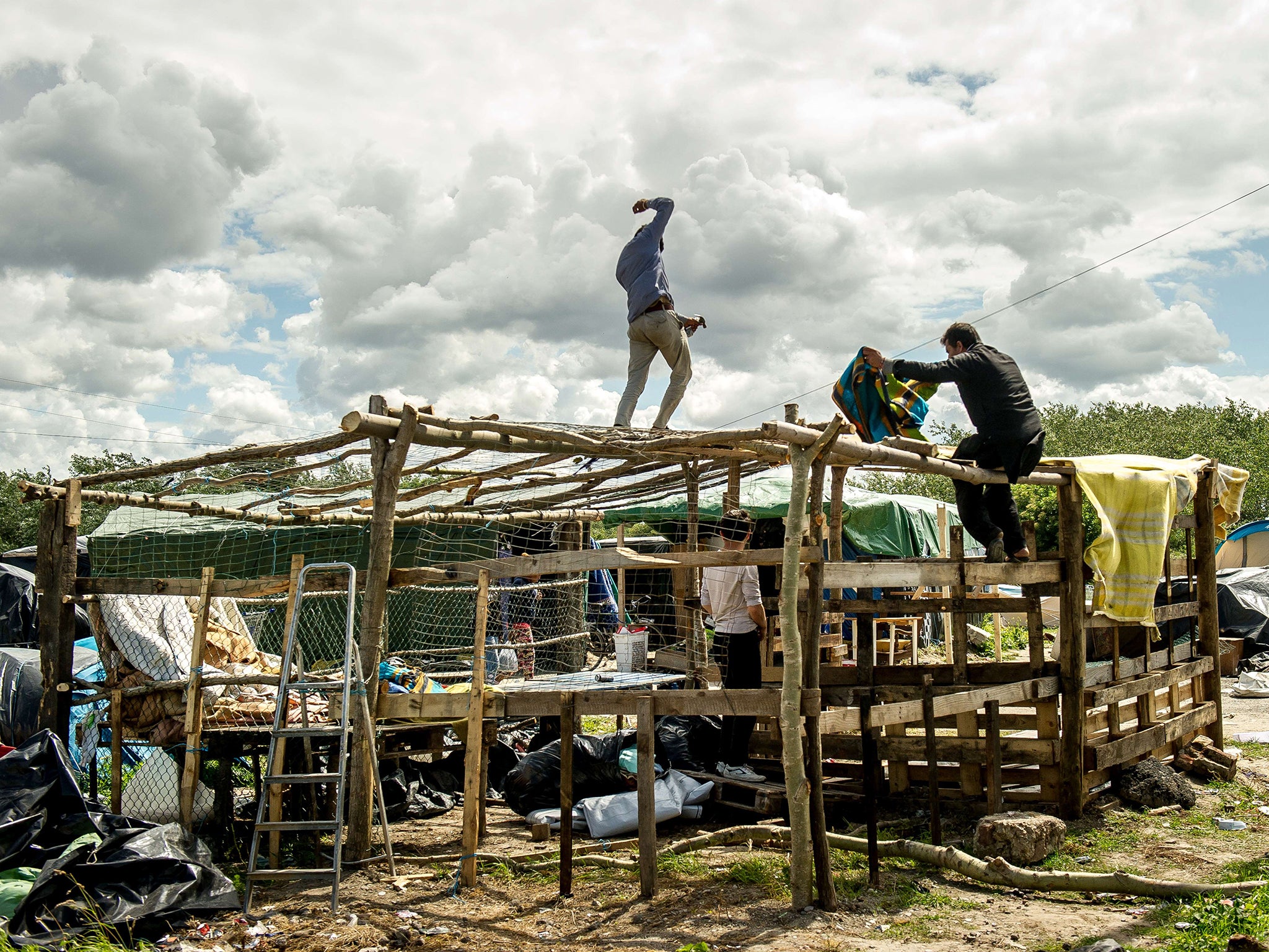 Migrants build a makeshift shelter around the northern French port of Calais