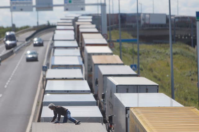 A driver climbs on his truck as he waits to cross the English channel, in Calais