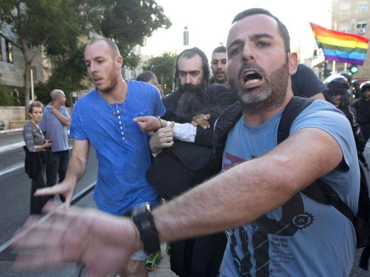 Plainclothes Israeli police detain an-ultra Orthodox Jew after he attacked people with a knife during a Gay Pride parade