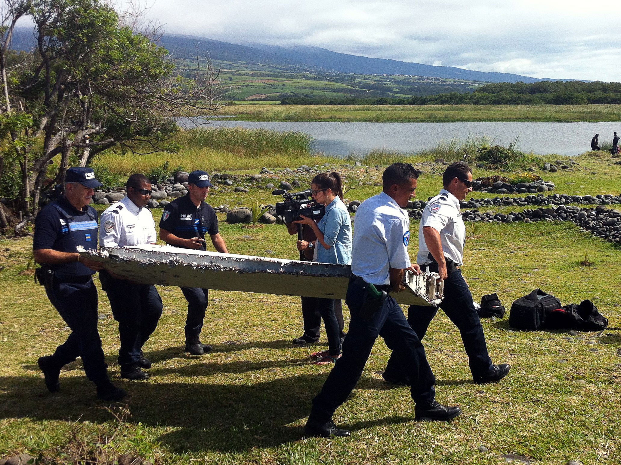 Police carry the possible MH370 debris, which has been sent to France for investigation