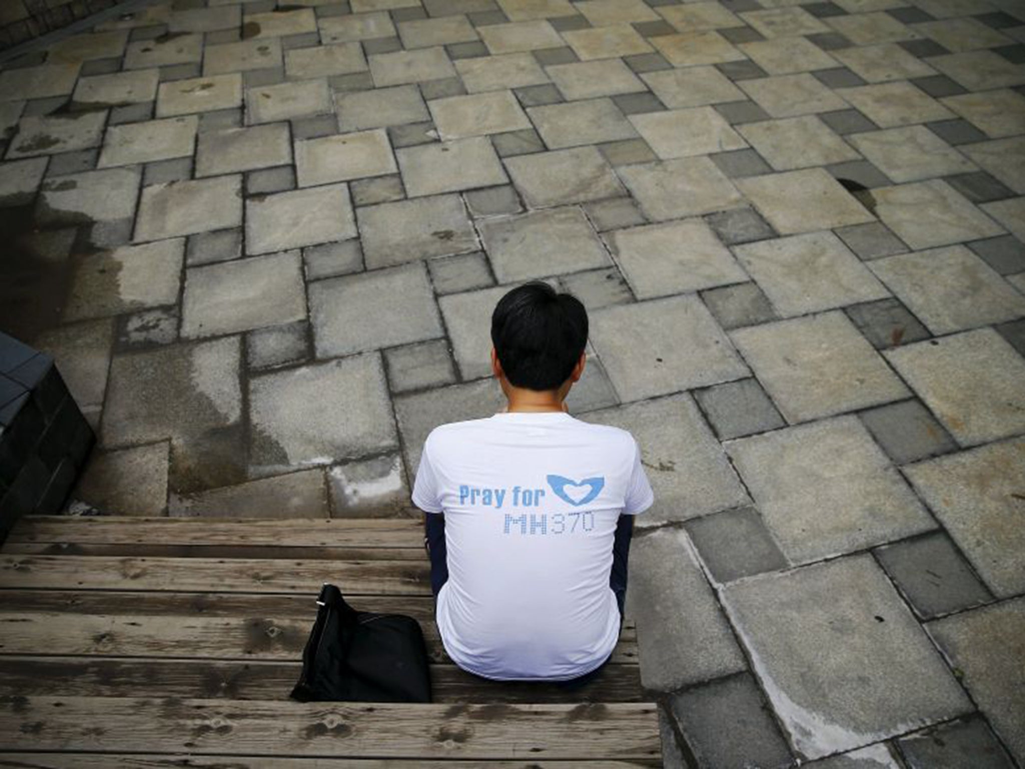 Jiang Hui, whose mother was on MH370, checks news about the Réunion wreckage on his mobile