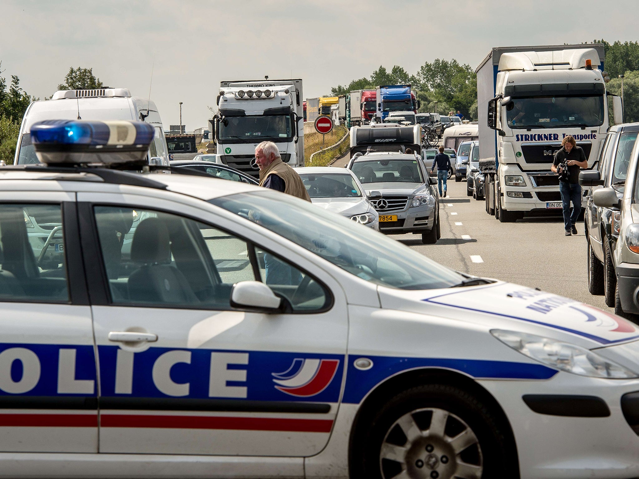 Motorists wait in their cars as striking employees of the My Ferry Link company block the access to the harbour in Calais