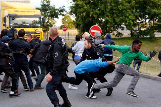 Migrants escape from the French Police as they try to catch a train to reach England