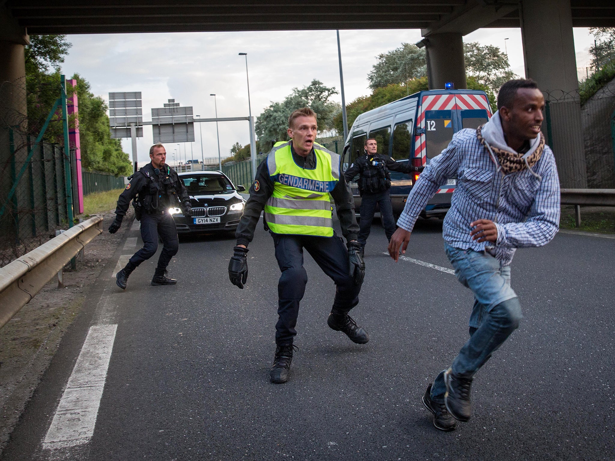 A man runs away from Gendarmerie near the Eurotunnel terminal in Coquelles