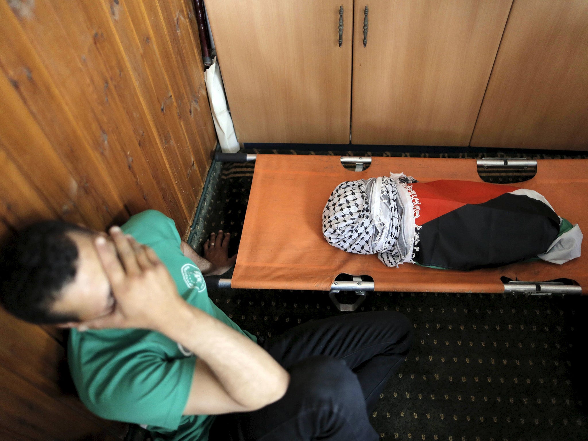 A relative mourns next to the body of the 18-month-old Palestinian baby Ali Dawabsheh (Oren Ziv/Getty Images)