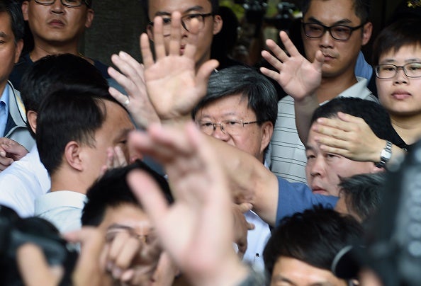 Security staff stop protesters from throwing bottles at Education Minister Wu Se-hwa (centre) as the crowd called for him to resign over the island's 'China-centric' curriculum (via SAM YEH/AFP/Getty Images)