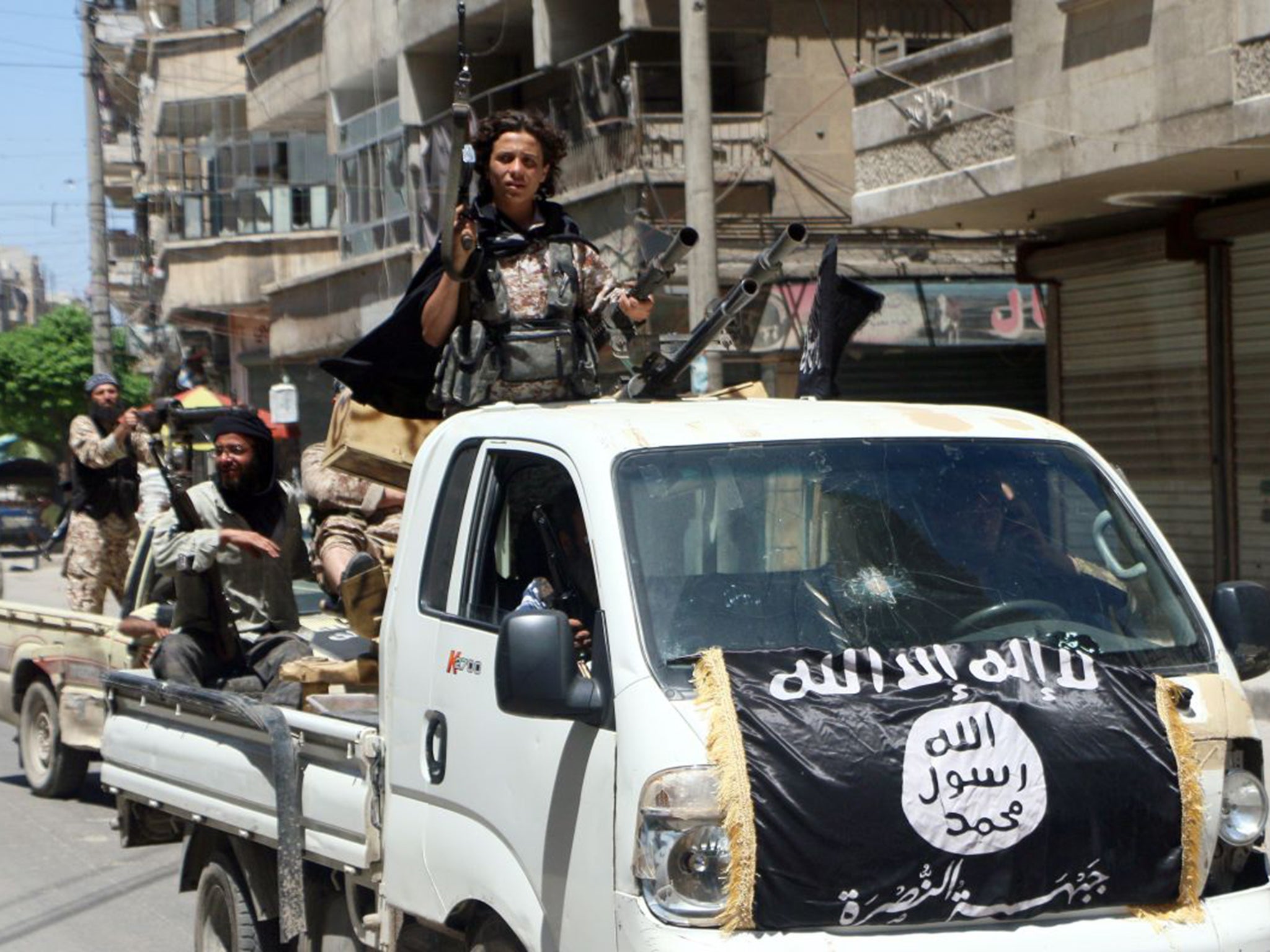 Jabhat al-Nusra fighters drive in armed vehicles through the northern Syrian city of Aleppo towards the frontline