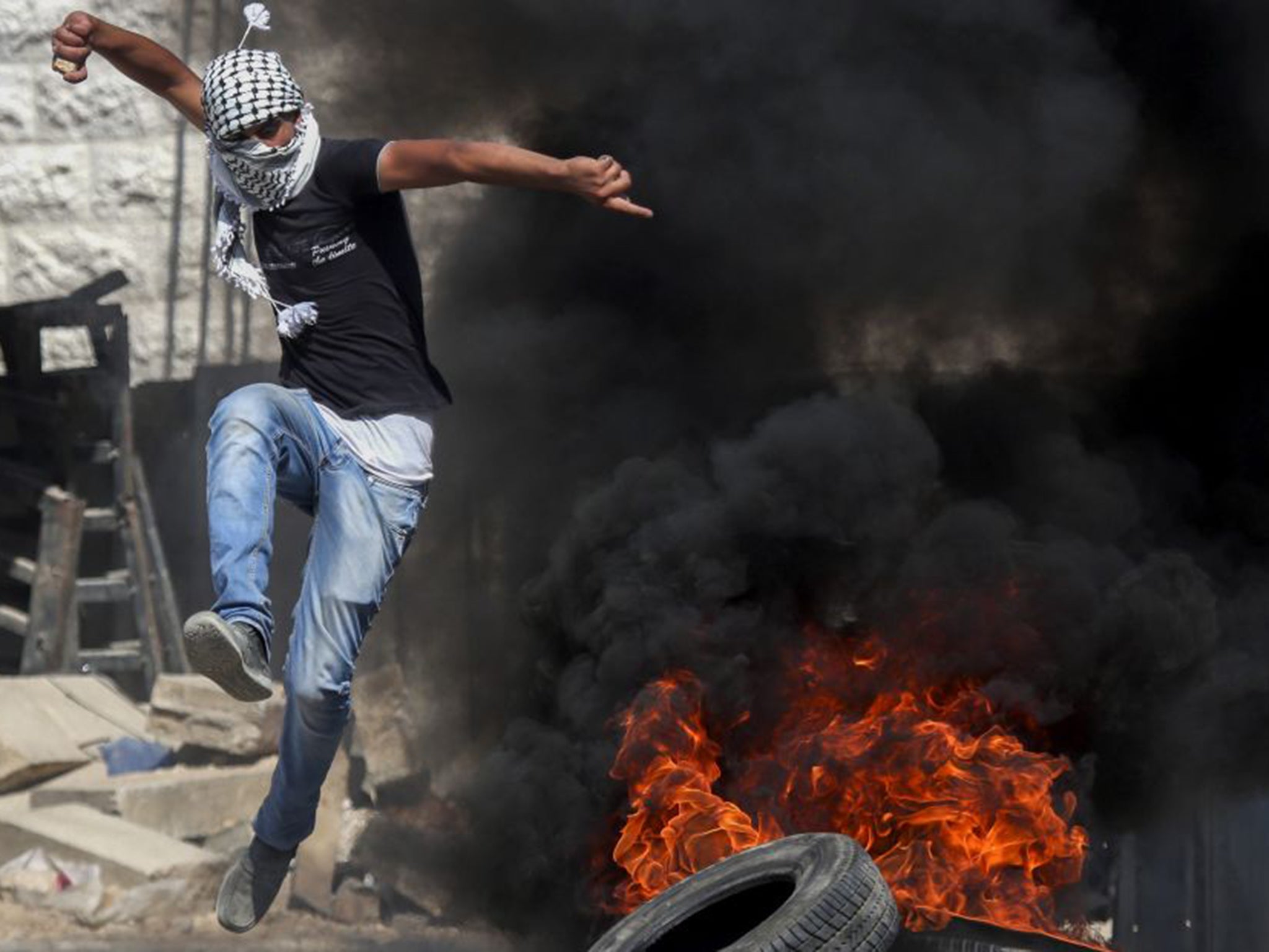 A man protests in Hebron about the fatal arson attack in Duma