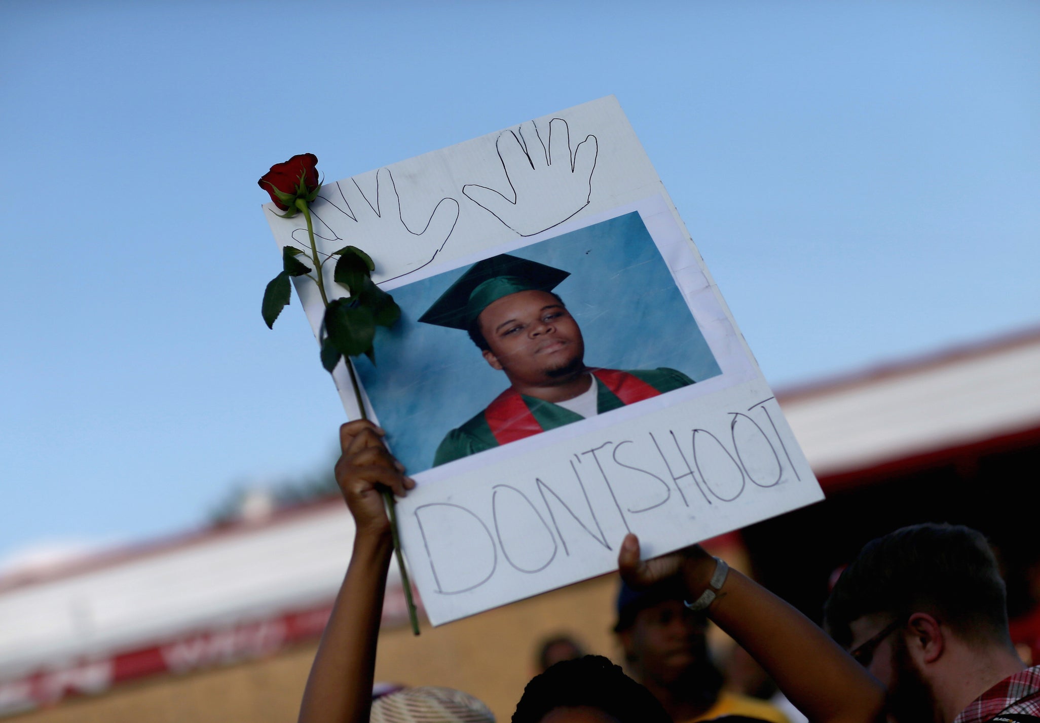 A demonstrator holds a sign reading "Dont Shoot" with images of Michael Brown on 17 August 2014 in Ferguson, Missouri.
