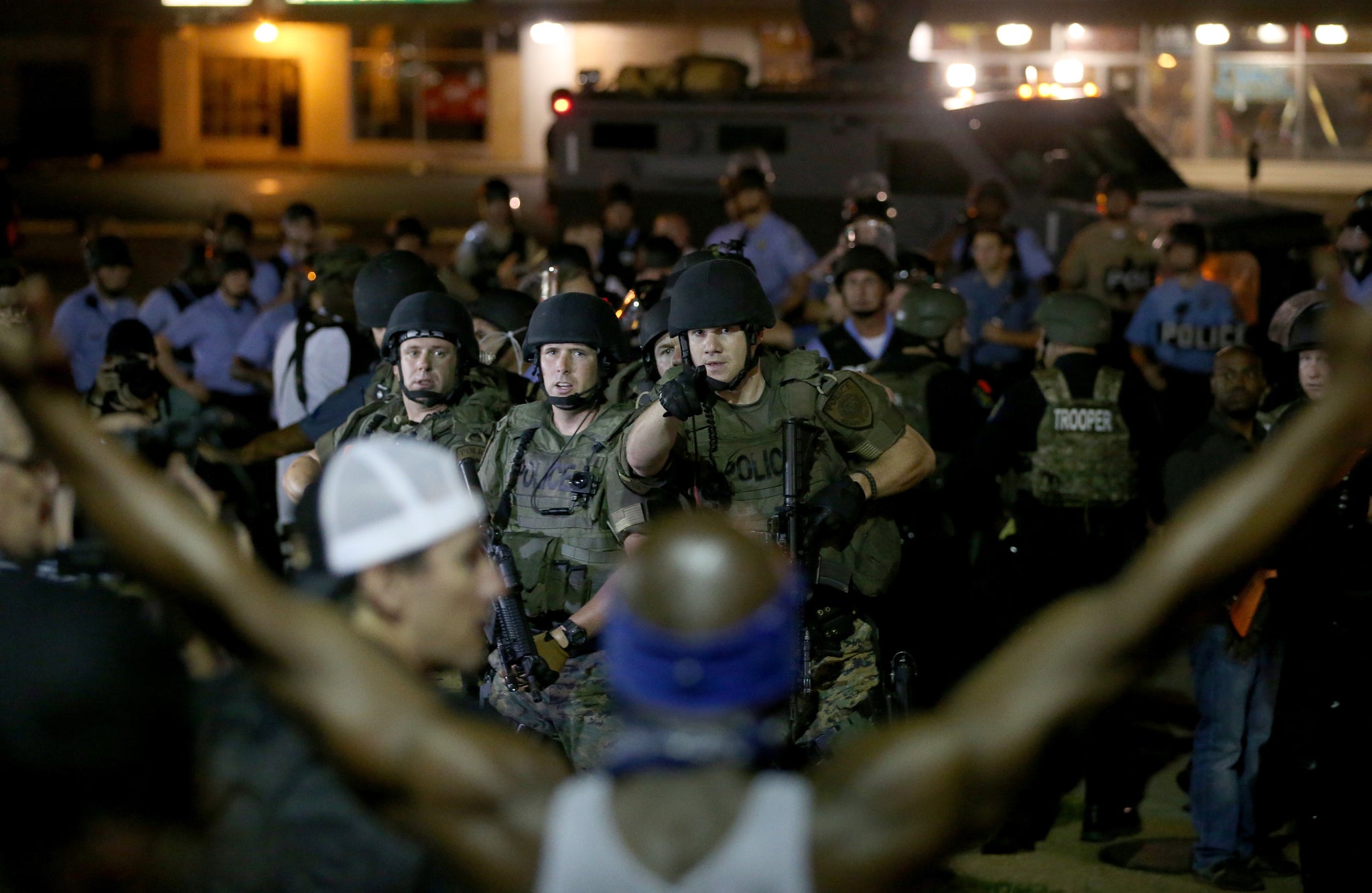 Police point to a demonstrator before arresting him on 19 August 2014 in Ferguson, Missouri.