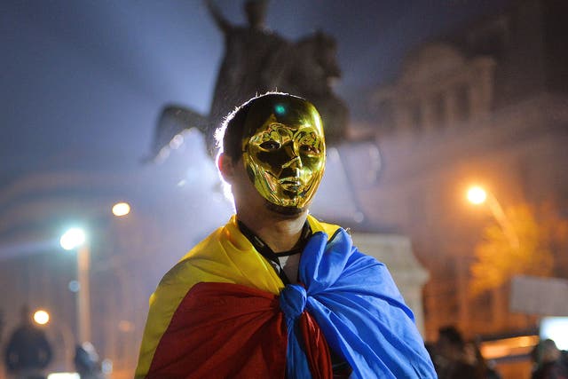 A protester wears a golden mask and Romanian flag during a demonstration in Bucharest against Gabriel Resources Rosia Montana gold and silver project
