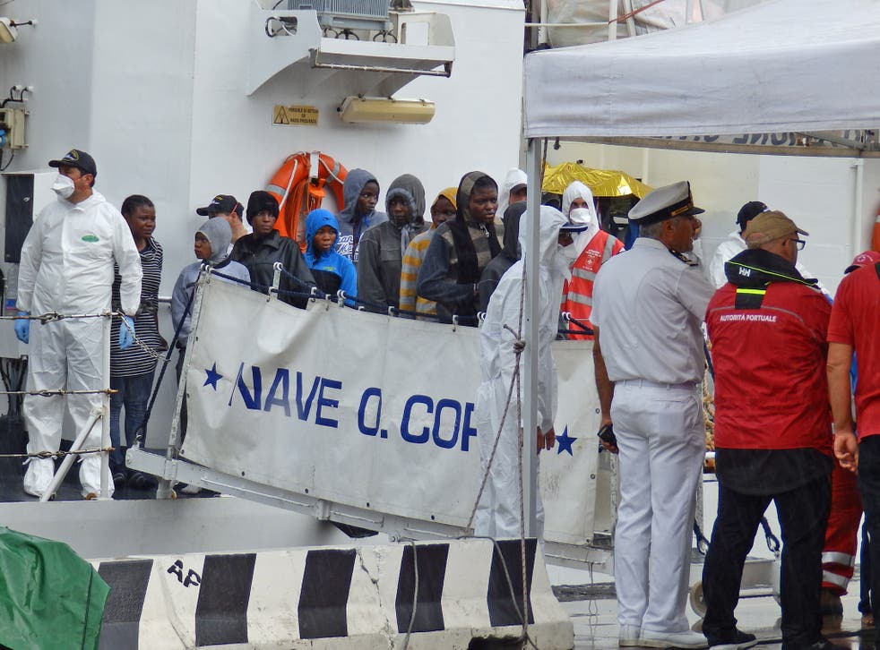 Migrants disembarking from an Italian coastguard ship in Messina 