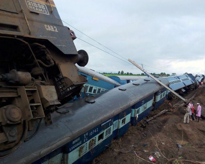The two derailed trains on top of each other in the mud