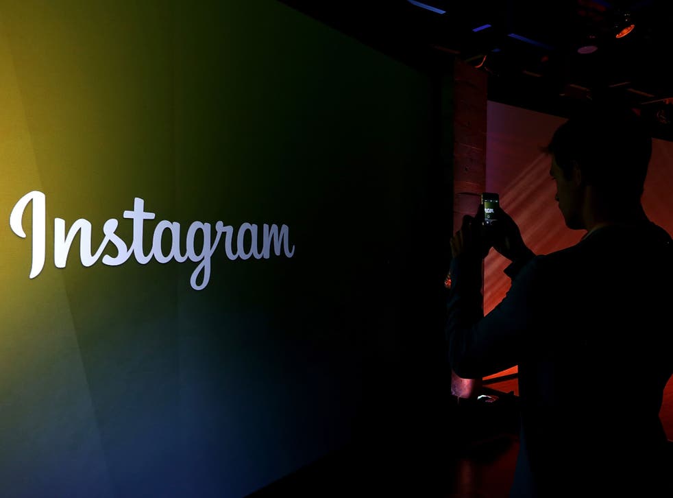 An attendee takes a photo of the instagram logo during a press event at Facebook headquarters on June 20, 2013 in Menlo Park, California
