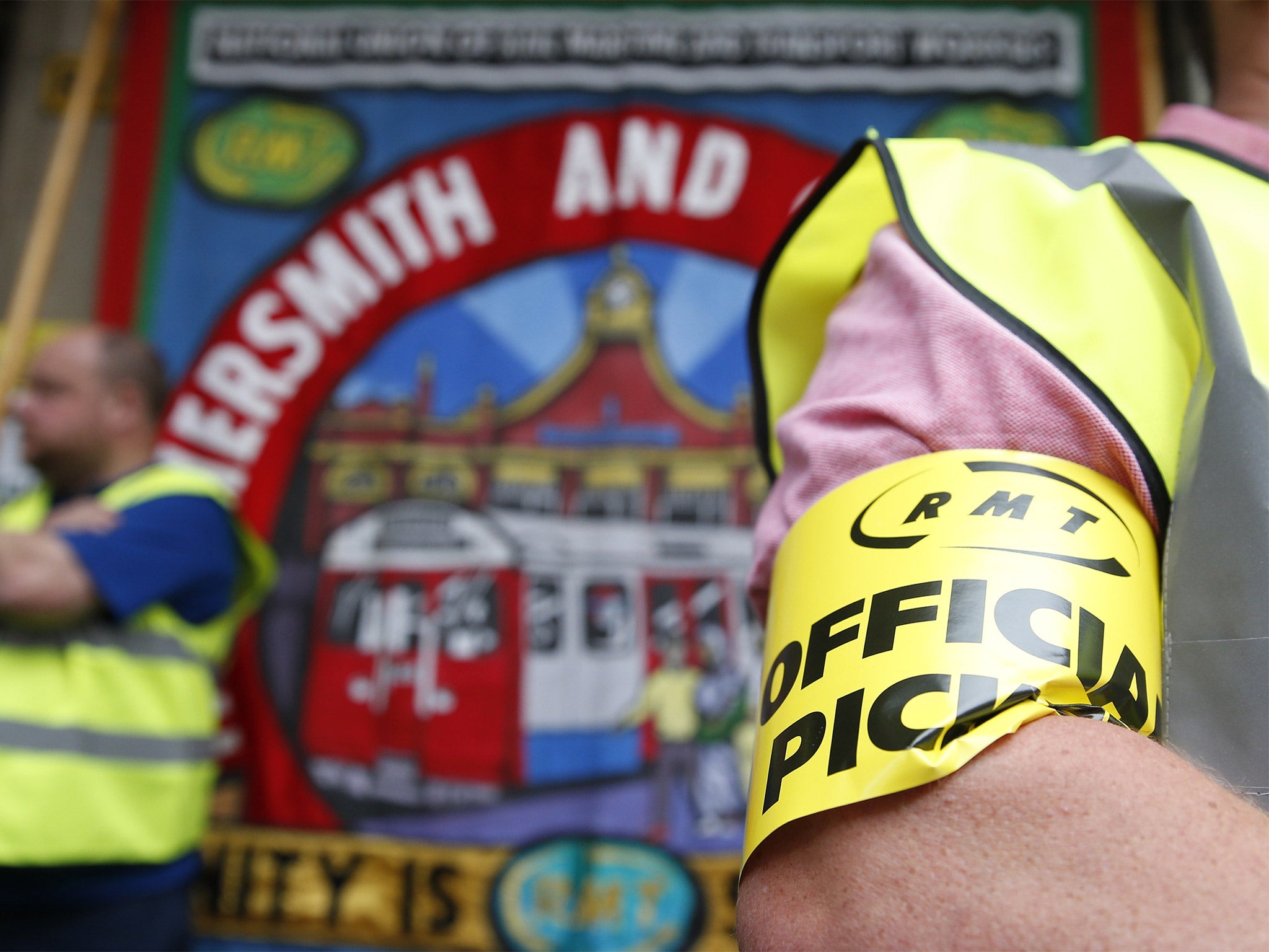 An RMT union member wears an official picket arm band outside Paddington Station