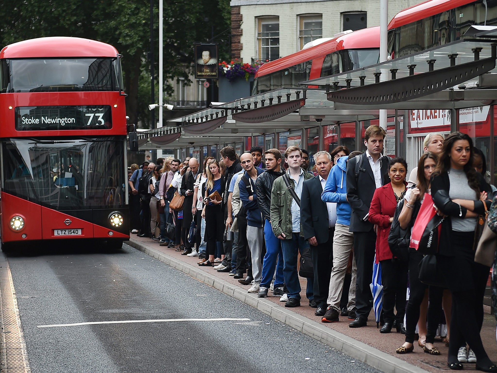 Commuters queue for buses during a tube strike at Victoria Station