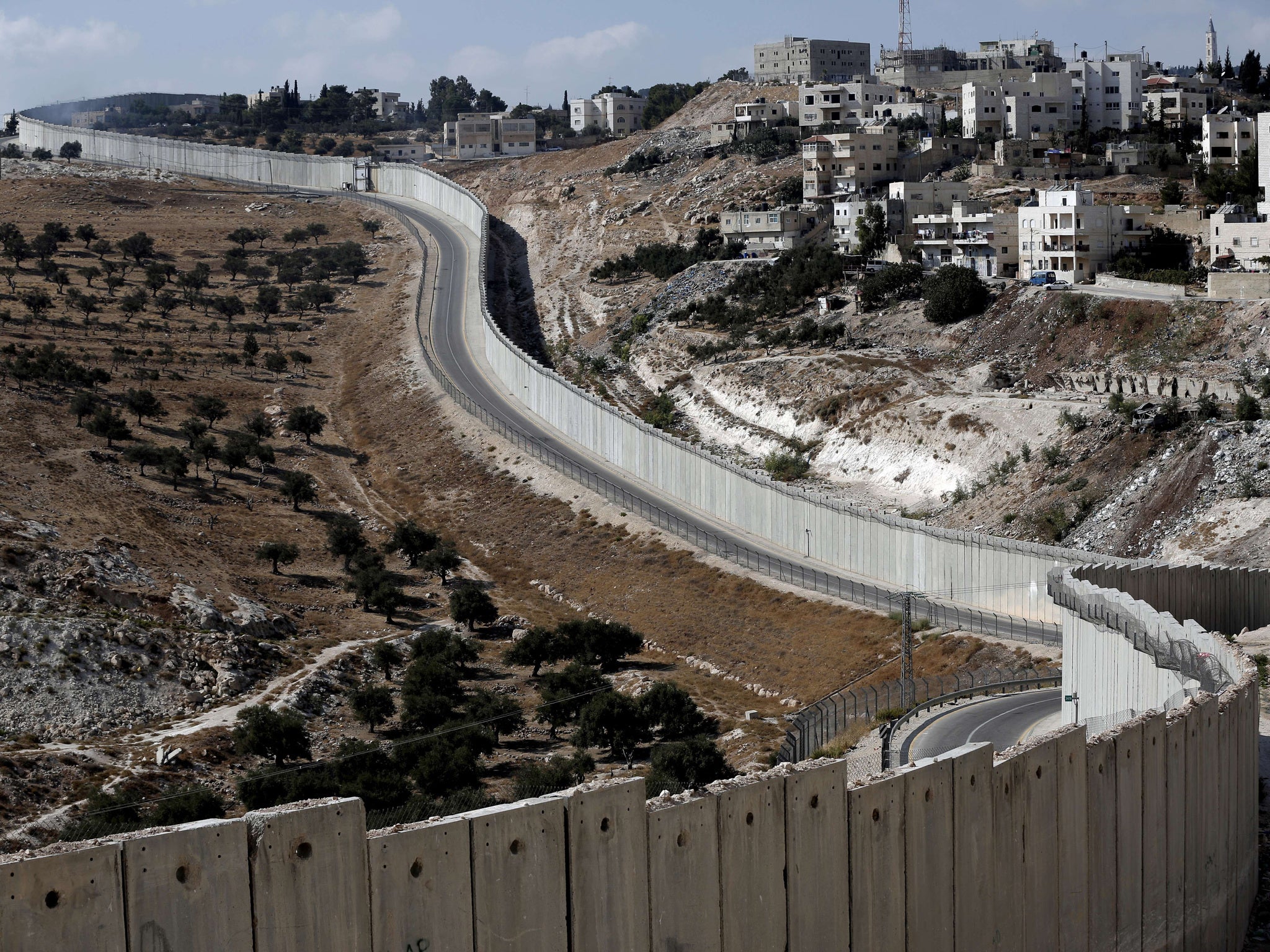 The Palestinian West bank city of Abu Dis is seen near the Israeli separation barrier