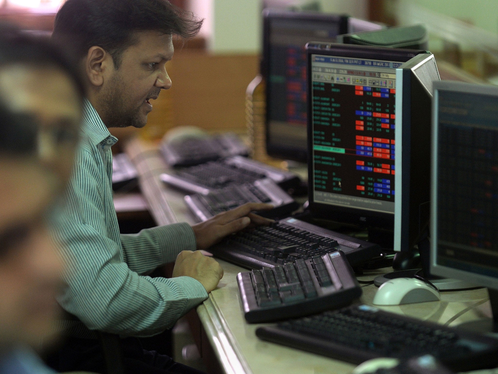 An Indian broker works at a computer terminal at a trading firm in Mumbai on December 9, 2013