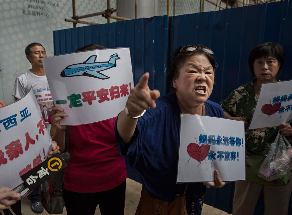 A Chinese relative of a missing passenger on Malaysia Airlines flight MH370 outside the airline's Beijing office on 6 August, 2015