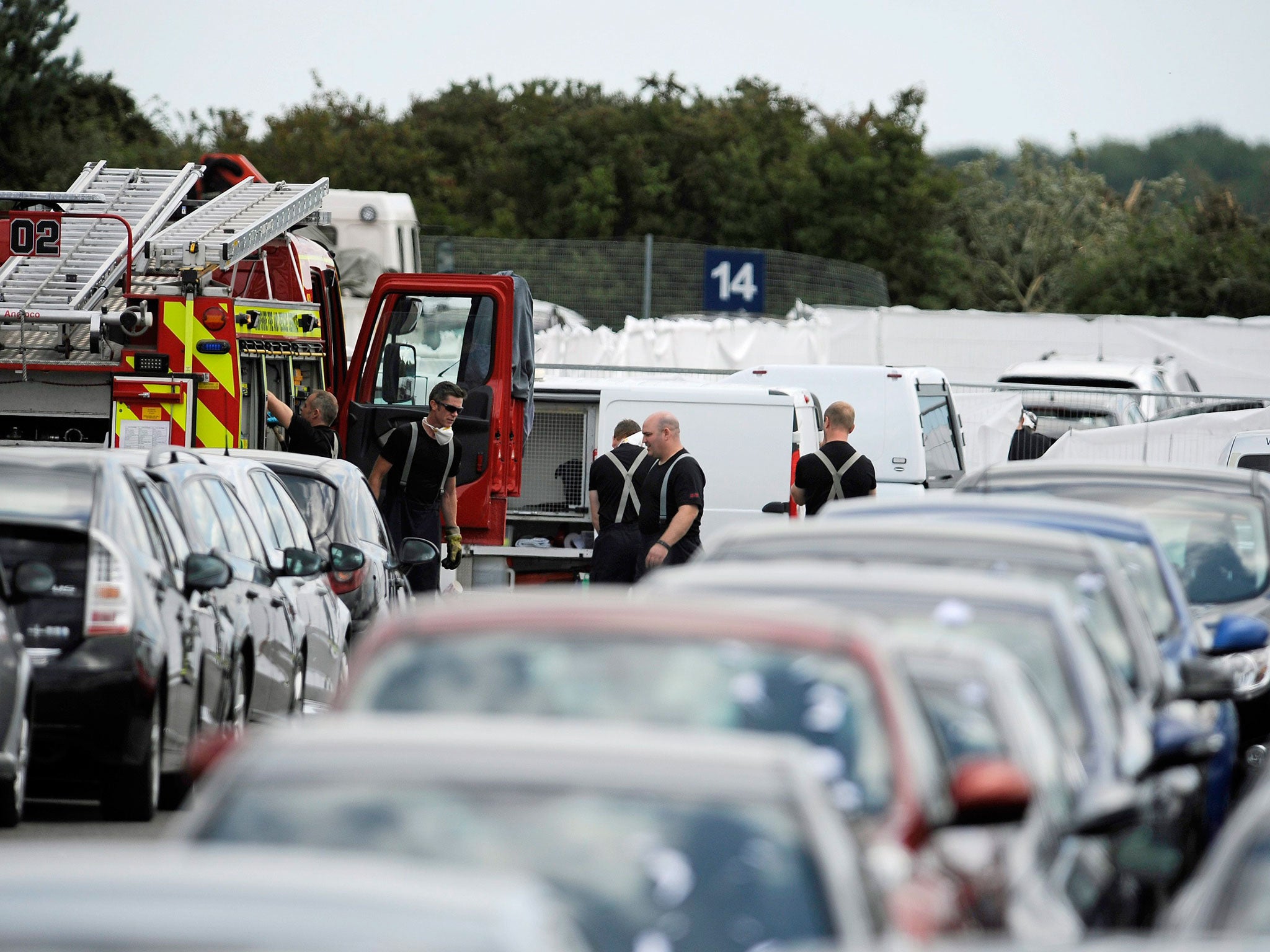 Hampshire police and firefighters at the scene of the Embraer Phenom 300 jet crash site at the British Car Auctions, Blackbushe, Hampshire