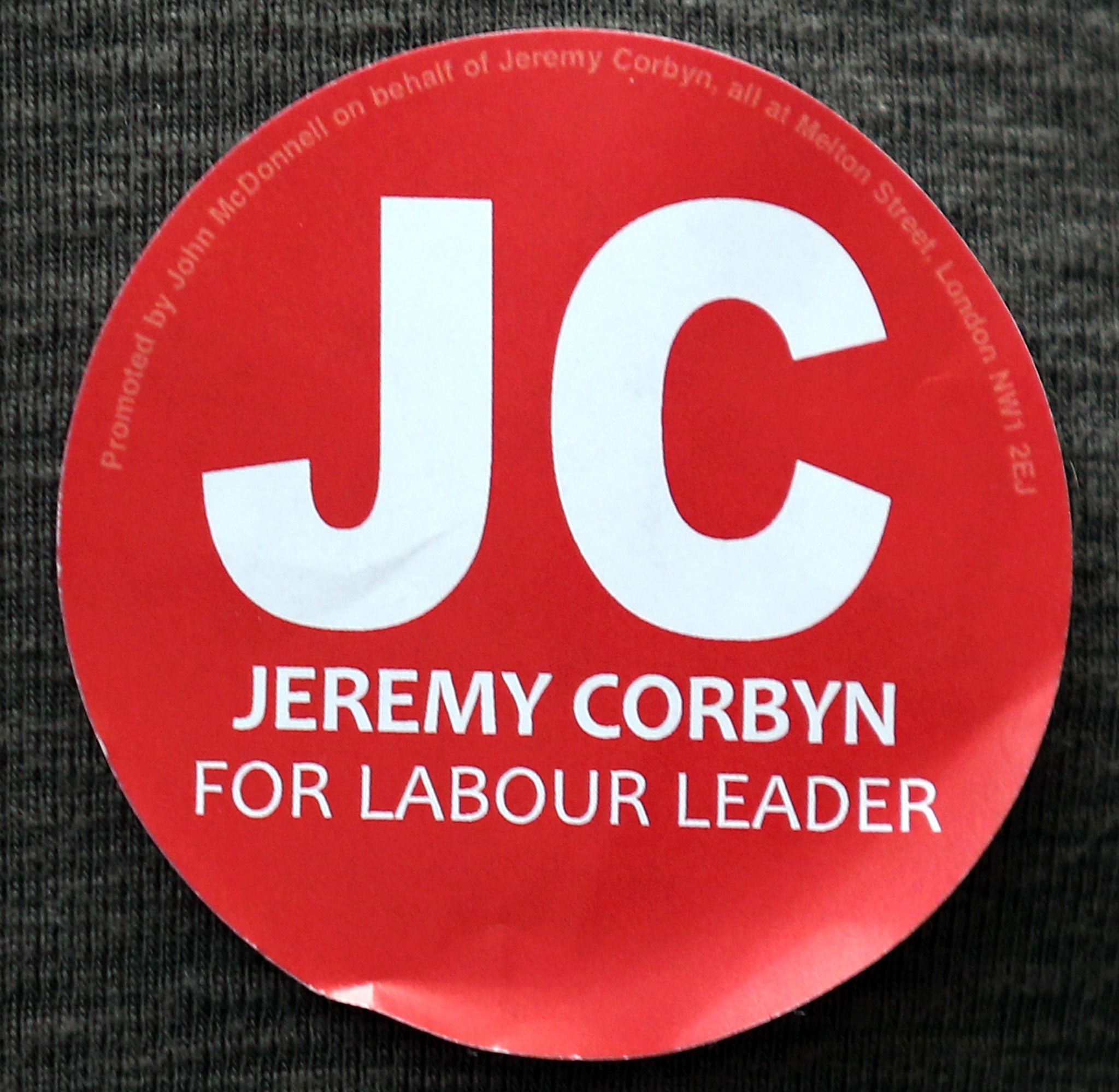 A close-up view of a sticker showing support for Jeremy Corbyn worn by a supporter at a Labour party leadership rally on August 3, 2015 in London