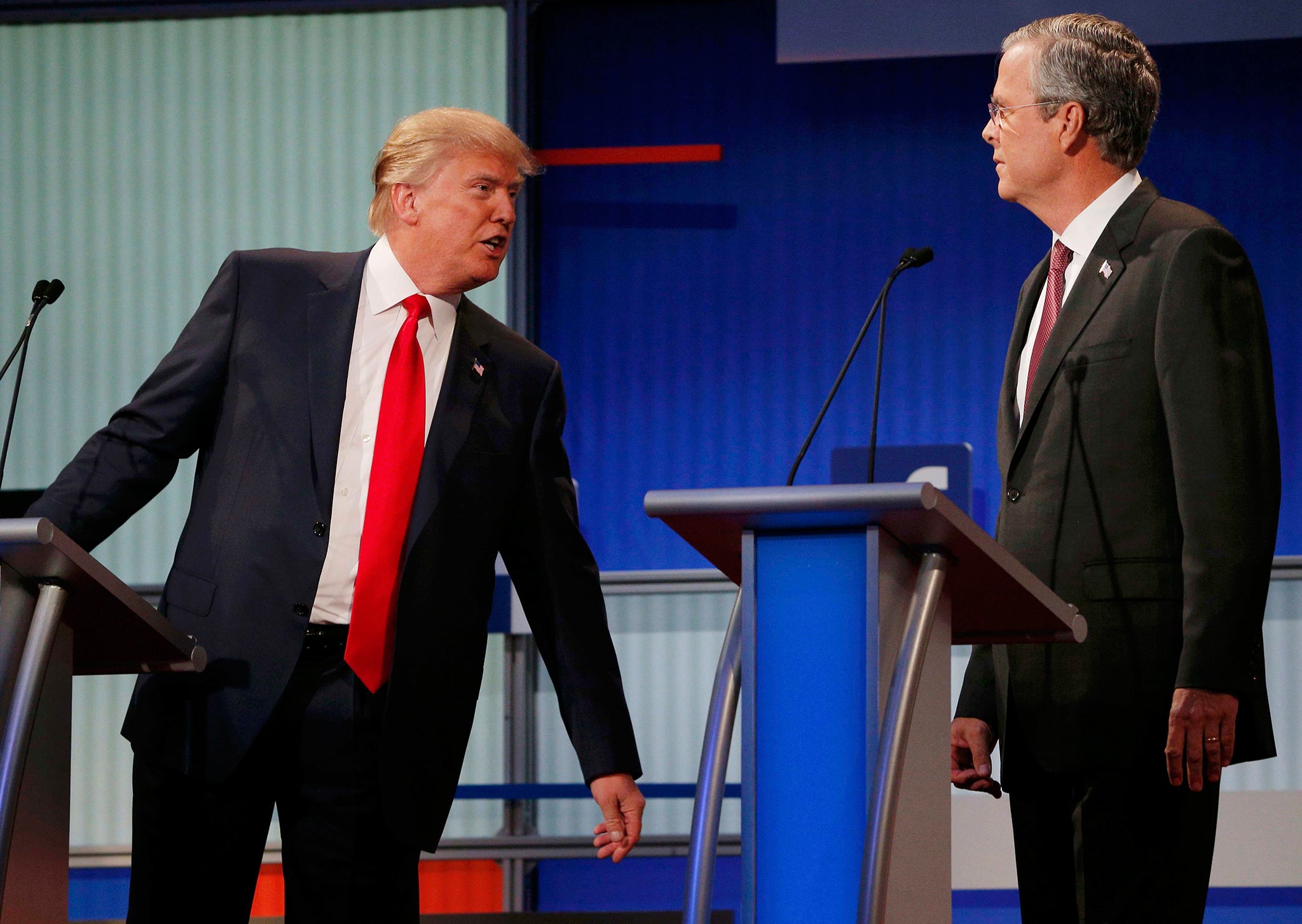 Republican 2016 U.S. presidential candidate businessman Donald Trump (L) talks with fellow candidate and former Governor of Florida Jeb Bush during a commercial break at the first official Republican presidential candidates debate of the 2016 U.S. preside