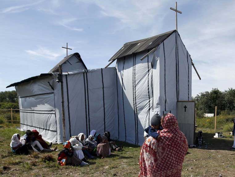 Christian migrants from Eritrea and Ethiopia attend the Sunday mass in the makeshift church