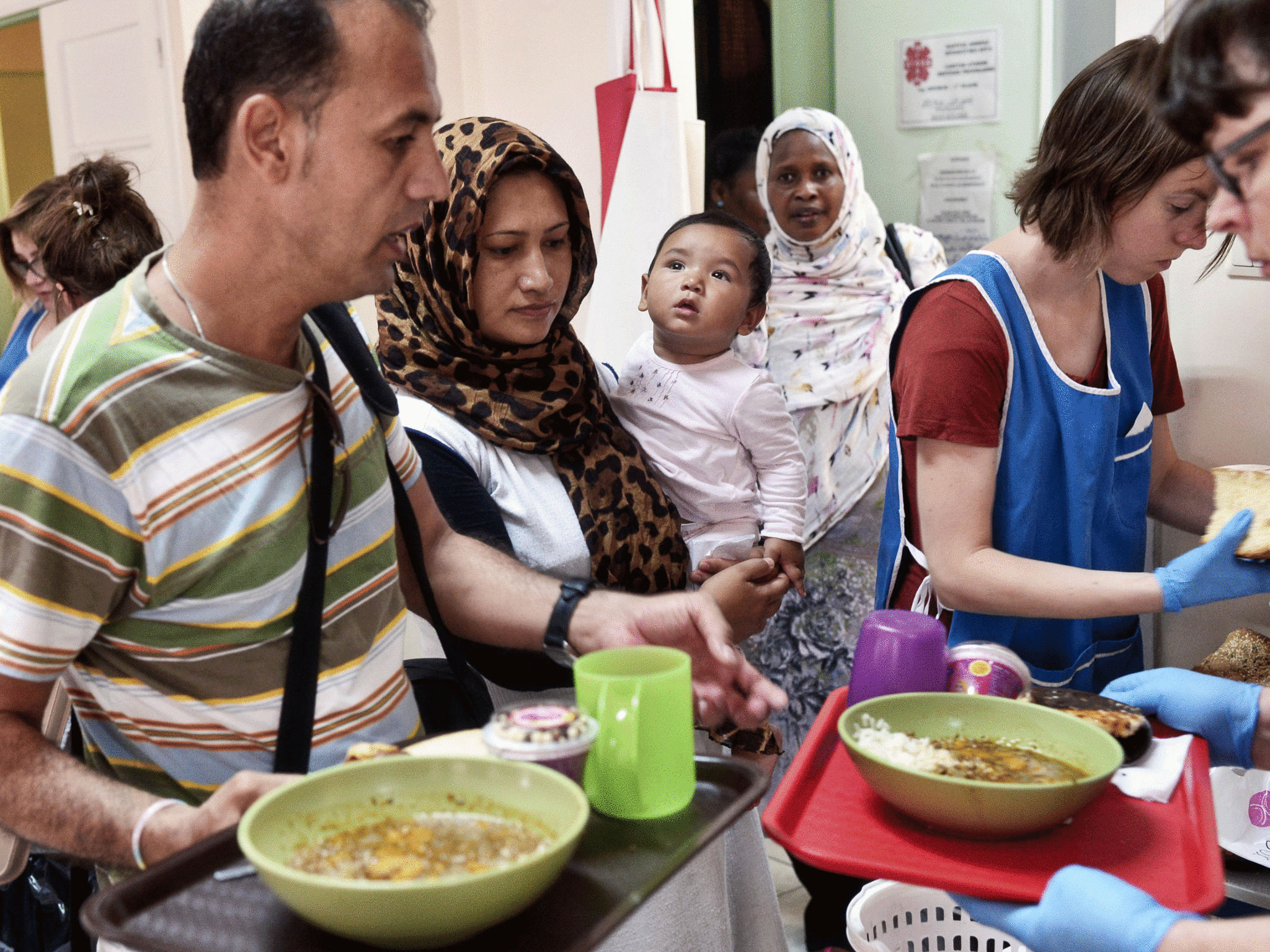 Migrants receive a meal offered by Caritas Greece on its premises in the centre of Athens