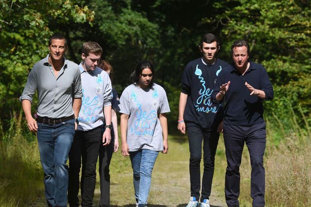Prime Minister David Cameron (right) and survival expert Bear Grylls (left) talk to members of the National Citizen Service during a visit to Oaklands Outdoor Education Centre in Snowdonia