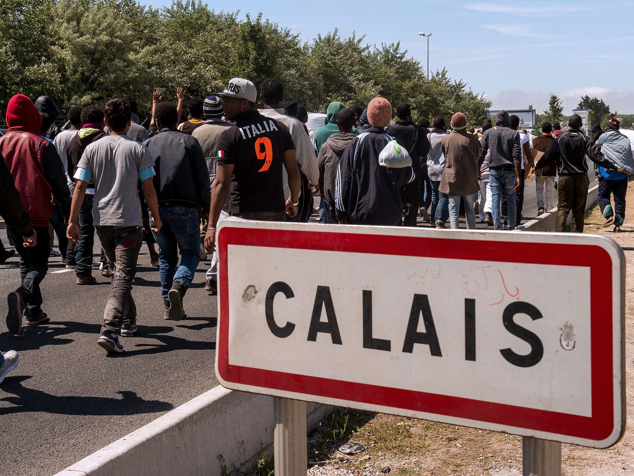 Migrants walk towards the ferry port of Calais, northern France.