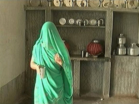A rape victim from Gujarat is being made to balance a rock on her head