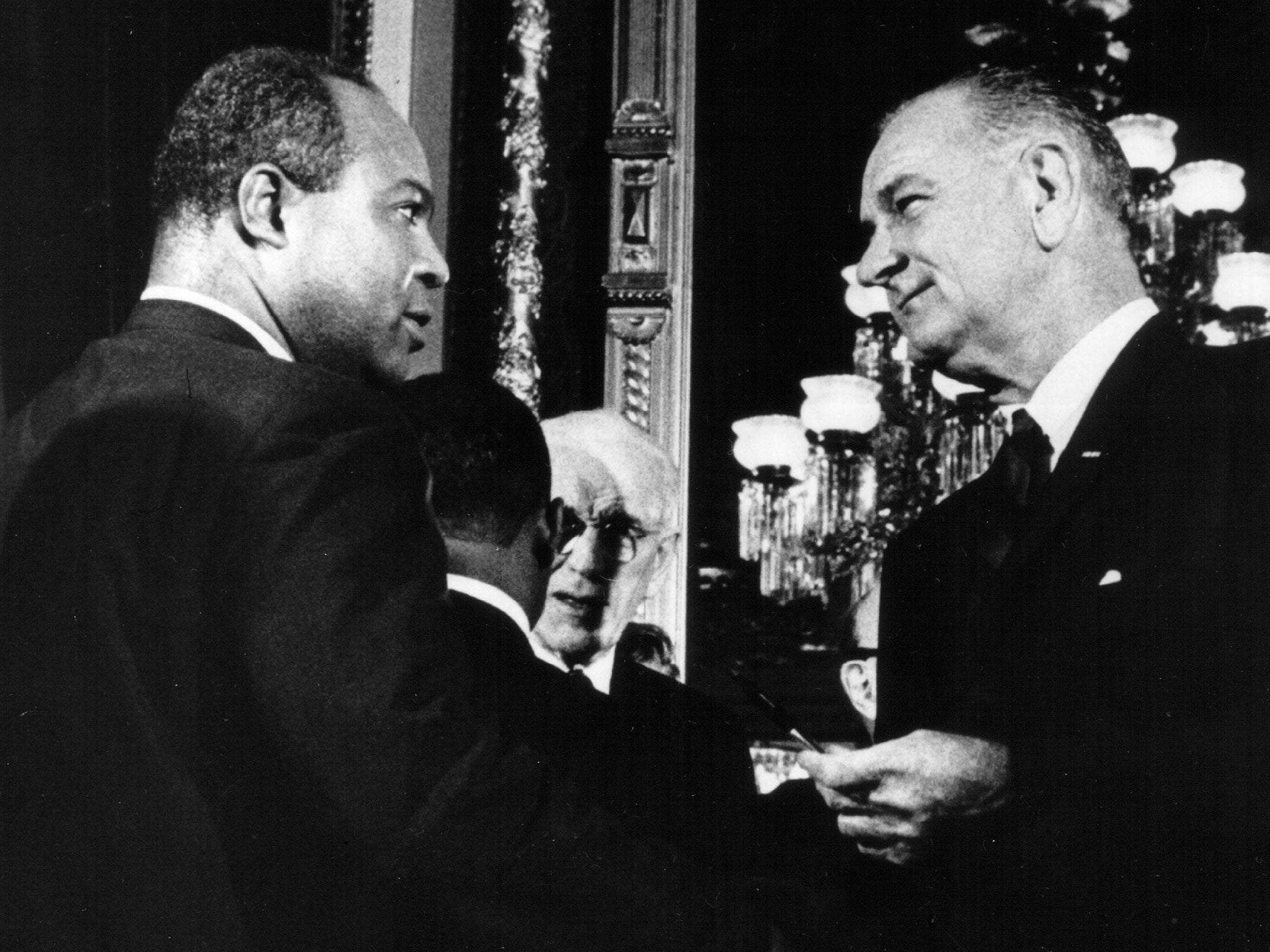President Lyndon B. Johnson presents one of the pens used to sign the Voting Rights Act of 1965 to James Farmer, Director of the Congress of Racial Equality on August 6, 1965