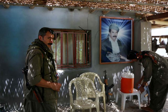 Members of the Kurdistan Workers' Party (PKK) rest in front of a portrait of jailed Kurdish rebel chief Abdullah Ocalan at a camp on July 29, 2015 