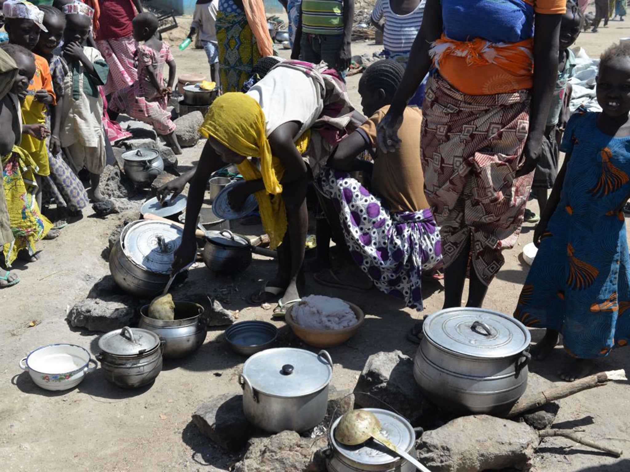 Women prepare food on in a camp for Nigerian refugees in Minawao