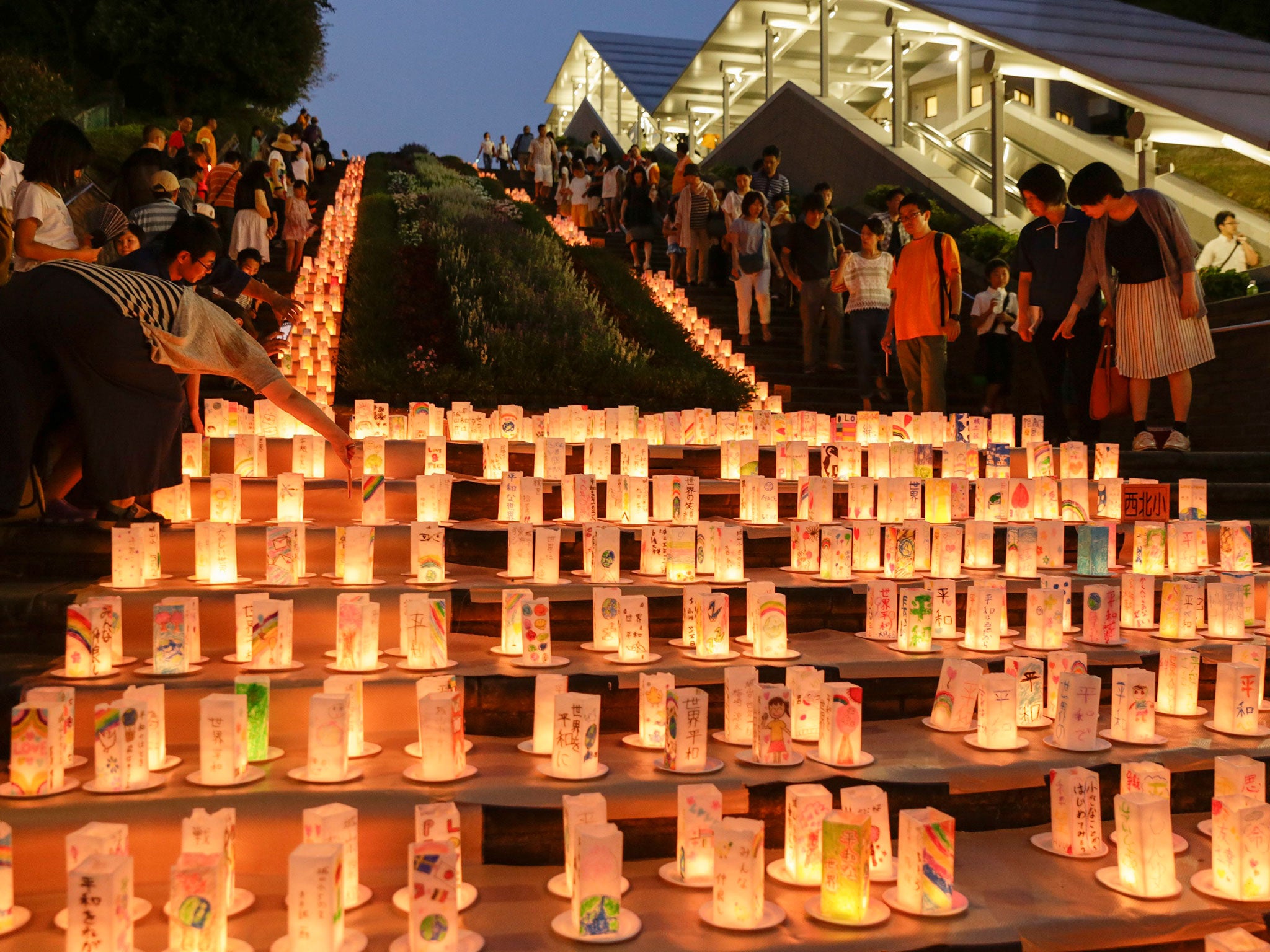Visitors look at paper lanterns displayed for the Peace Candle Lights at Nagasaki Peace Park (EPA)