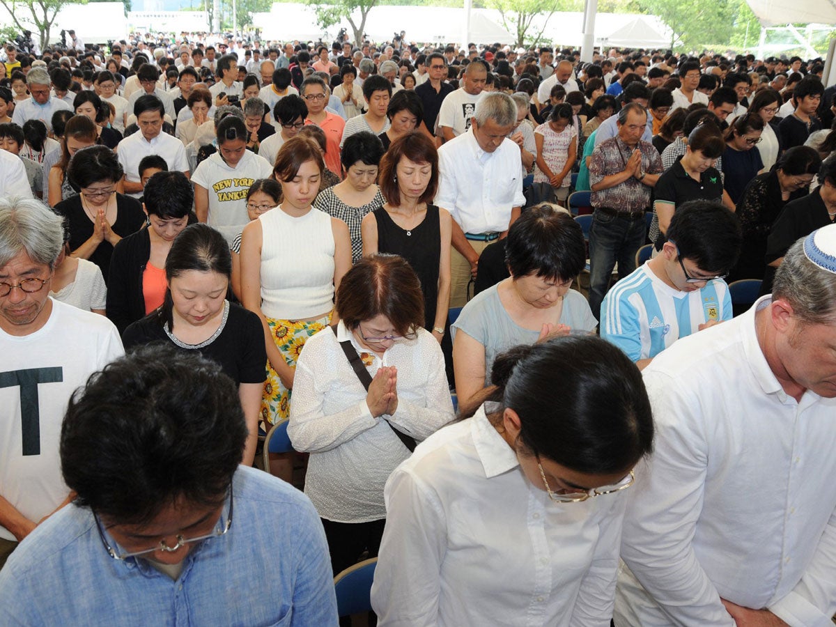 People offer silent prayers during the memorial ceremony