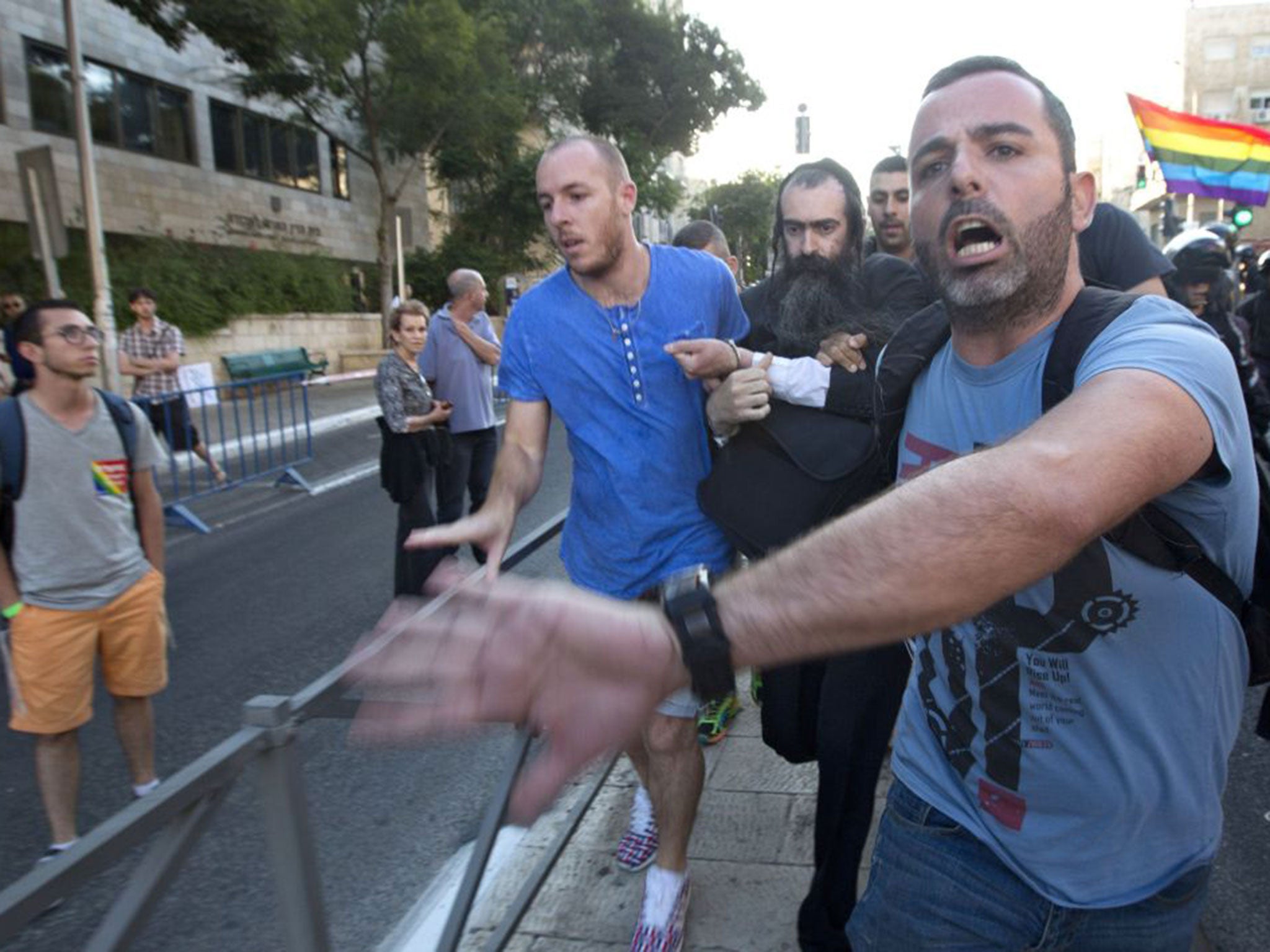 Yishai Schlissel is led away by Israeli plain clothes police officers after the Gay Pride march stabbing