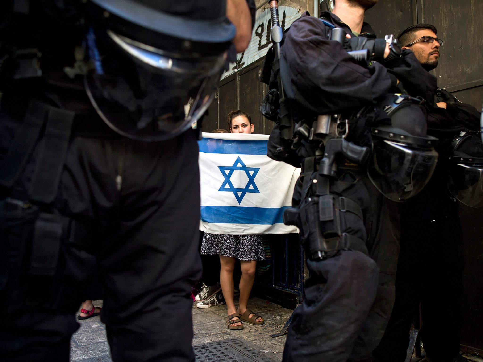 A Jewish girl holding an Israeli flag at the entrance to the al-Aqsa mosque in Jerusalem