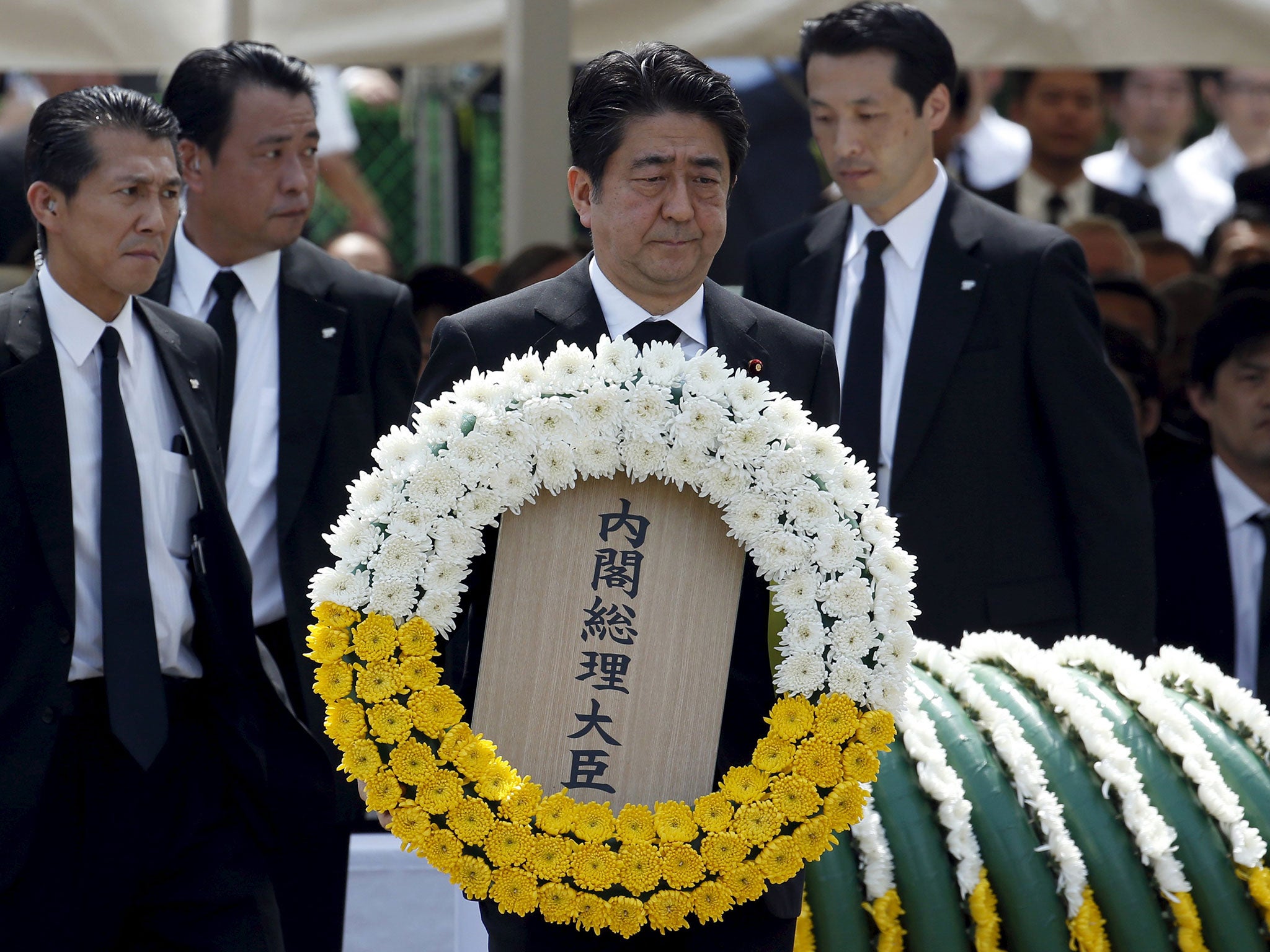 Japan's Prime Minister Shinzo Abe offers a flower wreath for the victims of the 1945 atomic bombing, during a ceremony commemorating the 70th anniversary of the bombing of the city at Nagasaki's Peace Park