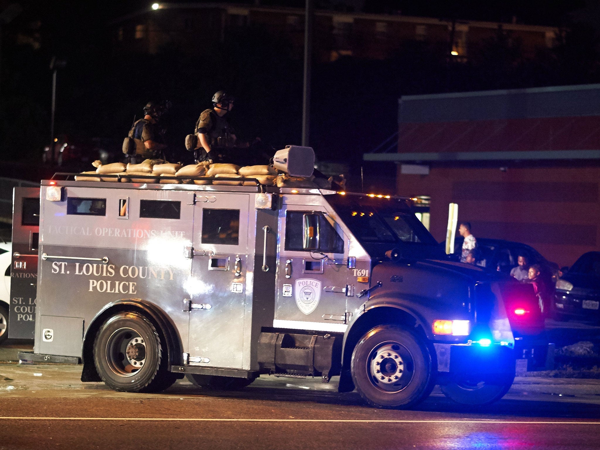 St. Louis County police officers respond in an MRAD vehicle after shots were fired during a protest march on August 9, 2015 on West Florissant Avenue in Ferguson, Missouri