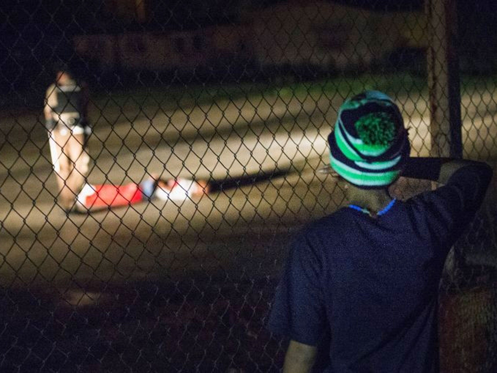 A young boy looks at Tyron Harris after he was shot (Image: Getty Images)