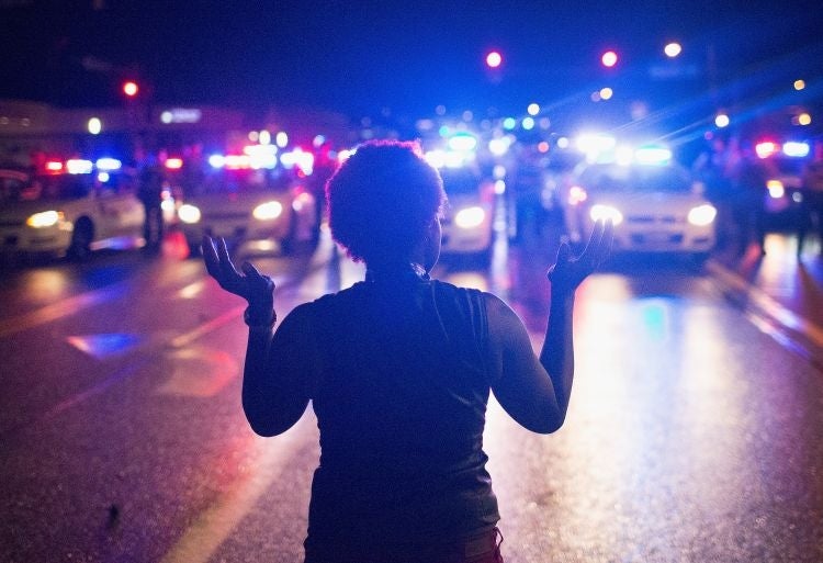 Demonstrators, marking the one-year anniversary of the shooting of Michael Brown, confront police
