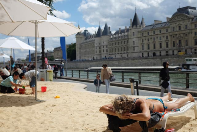 People relax on the sand during the 'Paris Plage' (Paris Beach) event on the banks of the river Seine in Paris