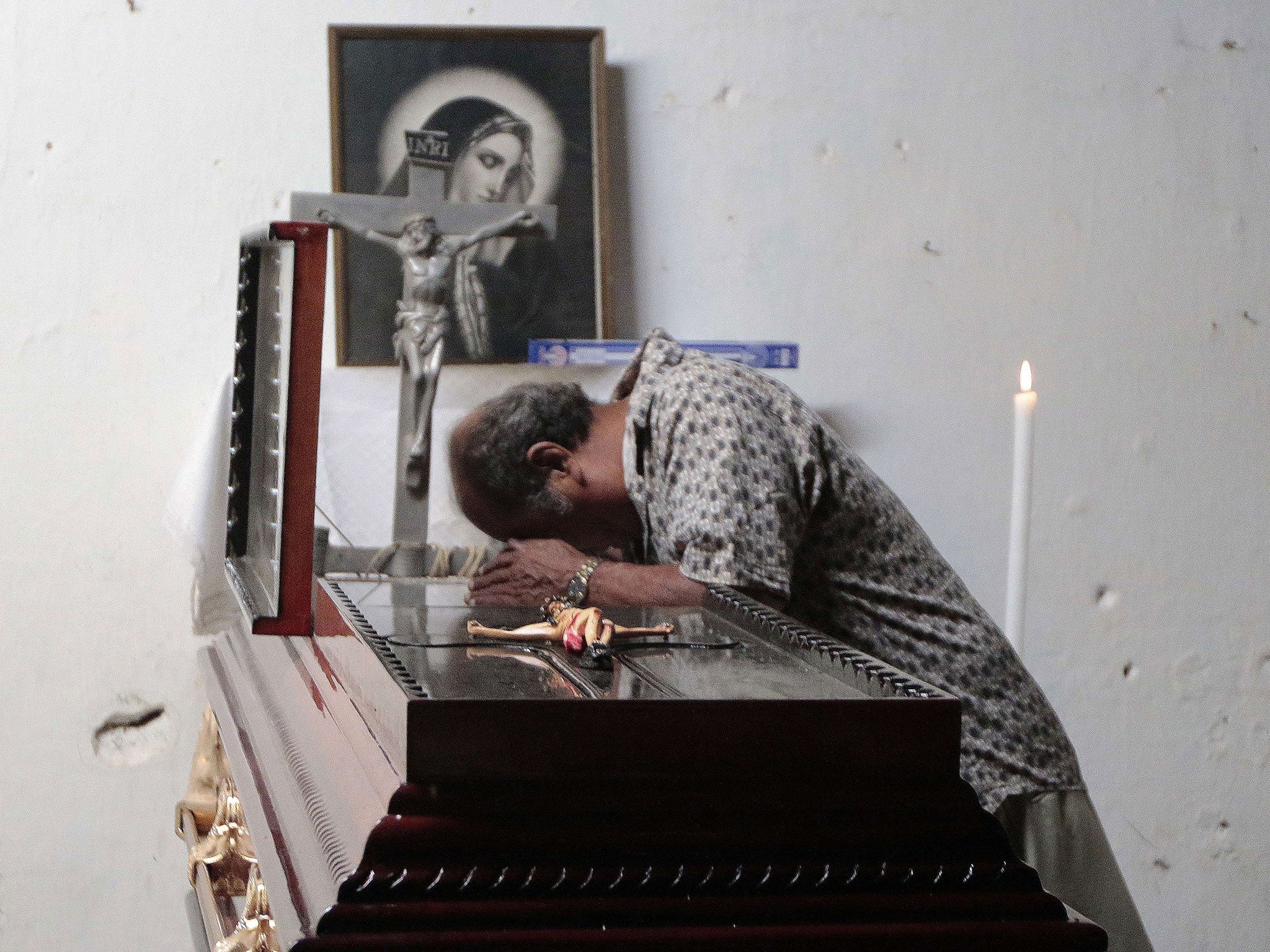 A man mourns over the coffin of activist Miguel Ángel Jiménez Blanco