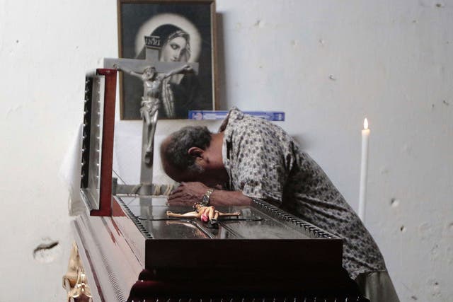 A man mourns over the coffin of activist Miguel Ángel Jiménez Blanco